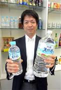 「サントリー天然水」のペットボトルを手に「消費者の声が『最軽量化』の後押しになった」と語る岸重信部長