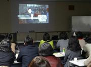 セミナー冒頭に流された映像。藤井さんが統合失調症について話しているが、画面には無関係のテロップが流れ続ける＝大阪市西区