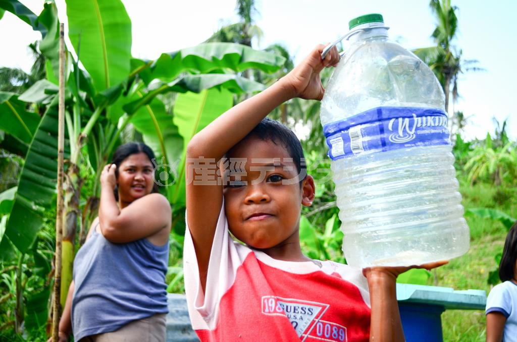 家族で飲む水を運ぶアレクサンダー君（６）。台風発生直後、ワールド・ビジョン・ジャパンはライフラインが破壊された地域に安全な水を届けた＝２０１４年３月３日、フィリピン・レイテ島タクロバン（ワールド・ビジョン・ジャパン撮影）