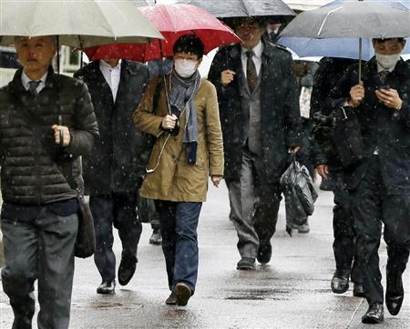 冷たい雨が降る中、通勤する人たち＝８日午前、東京・霞が関