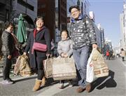 たくさんの荷物を手に東京・銀座の街を歩く中国人観光客＝７日午後