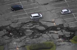 地震で崩れた駐車場＝１６日午前６時３１分、熊本県南阿蘇村