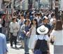 強い日差しの中、外国人や日本人でにぎわう道頓堀。日傘姿は少ない＝大阪市中央区