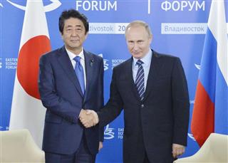 会談で握手する安倍晋三首相（左）とロシアのプーチン大統領＝９月２日、ロシア・ウラジオストク（共同）