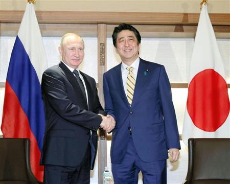 会談冒頭、ロシアのプーチン大統領（左）と握手を交わす安倍晋三首相＝１５日午後、山口県長門市（代表撮影）