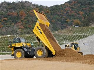 鹿島がダム工事に投入する自動ダンプカー。土砂を積むブルドーザーや振動ローラーも自動化した