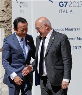 日本の麻生太郎財務相に歩み寄り、握手を求める仏のミシェル・サパン外相＝１３日、伊南部のバーリ（ＡＰ）