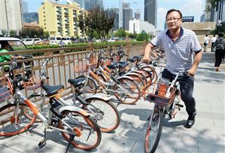 北京市内の繁華街で「Ｍｏｂｉｋｅ」のシェア自転車に乗る男性＝１７日（共同）