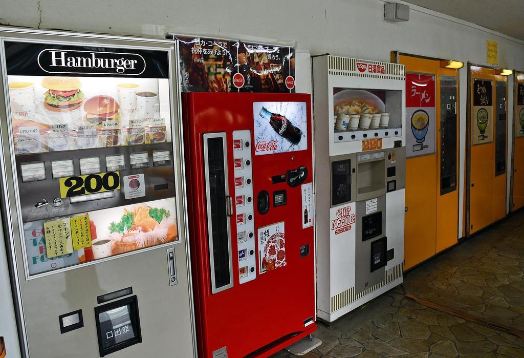 壁一面に並ぶ自販機。ハンバーガーや瓶のコーラ、カップヌードルなど、どこか昭和の香りを強く感じさせる