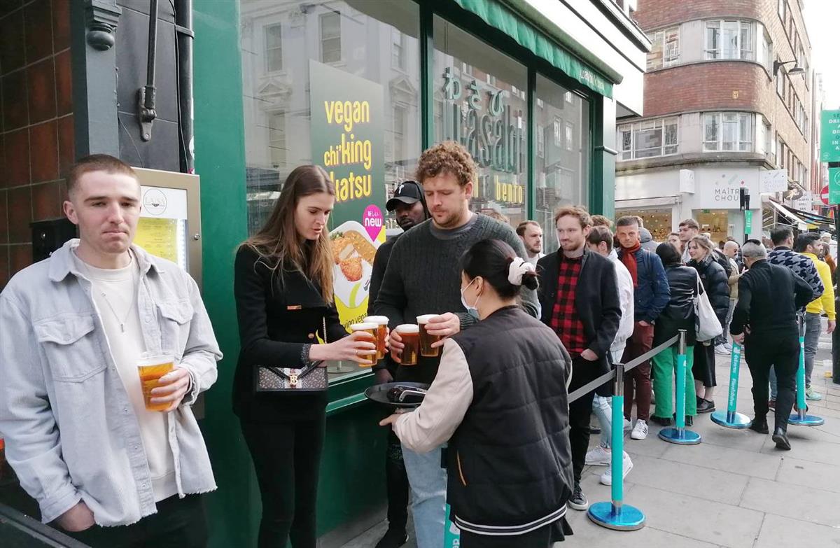 ロンドン中心部の飲食街でマスクをつけずに店の前で並ぶ市民＝１７日（板東和正撮影）