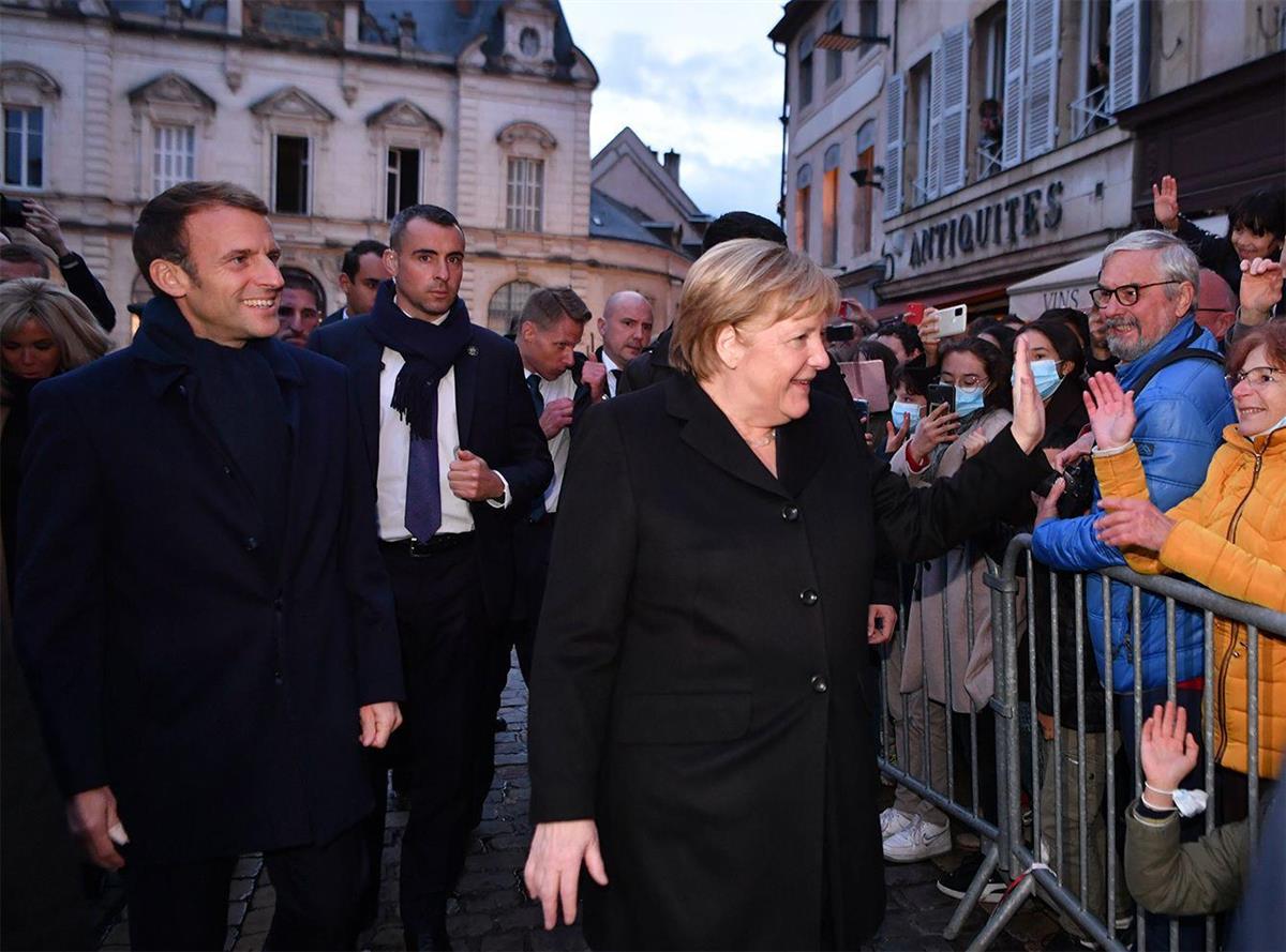 2021年11月3日、フランス東部のボーヌで、会談に先立ち一般市民に歓迎されるドイツのアンゲラ・メルケル首相（右）とフランスのエマニュエル・マクロン大統領（左） - 写真＝EPA／時事通信フォト